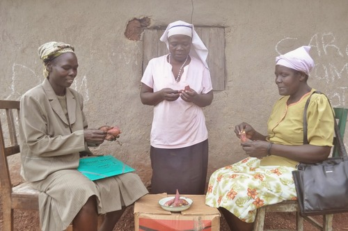 One Acre Fund farmers Olivia Chimoli (right), Agnes Machalero (center) and Beatrice Likhutsu (left) from Shimanyiro, Kenya, enjoy eating their newly harvested sweet potatoes. Photo by Kelvin Owino